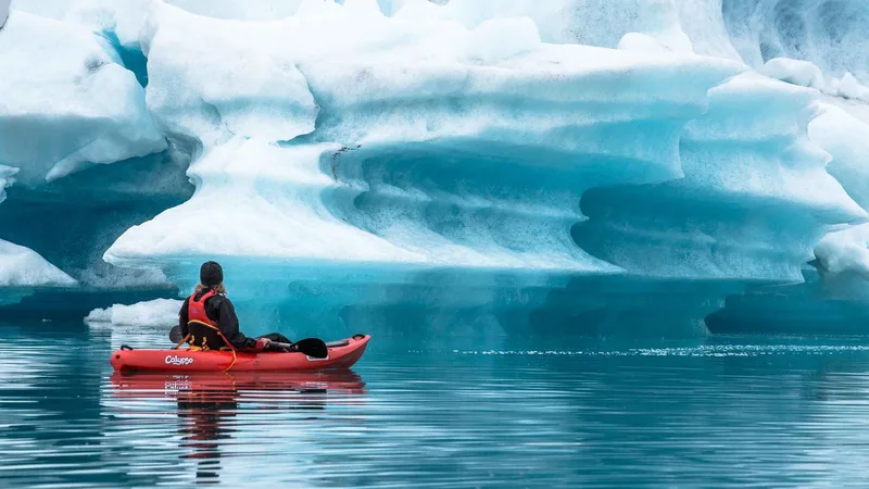 Kayakers paddling between icebergs on a Jökulsárlón glacier lagoon boat tour in South East Iceland